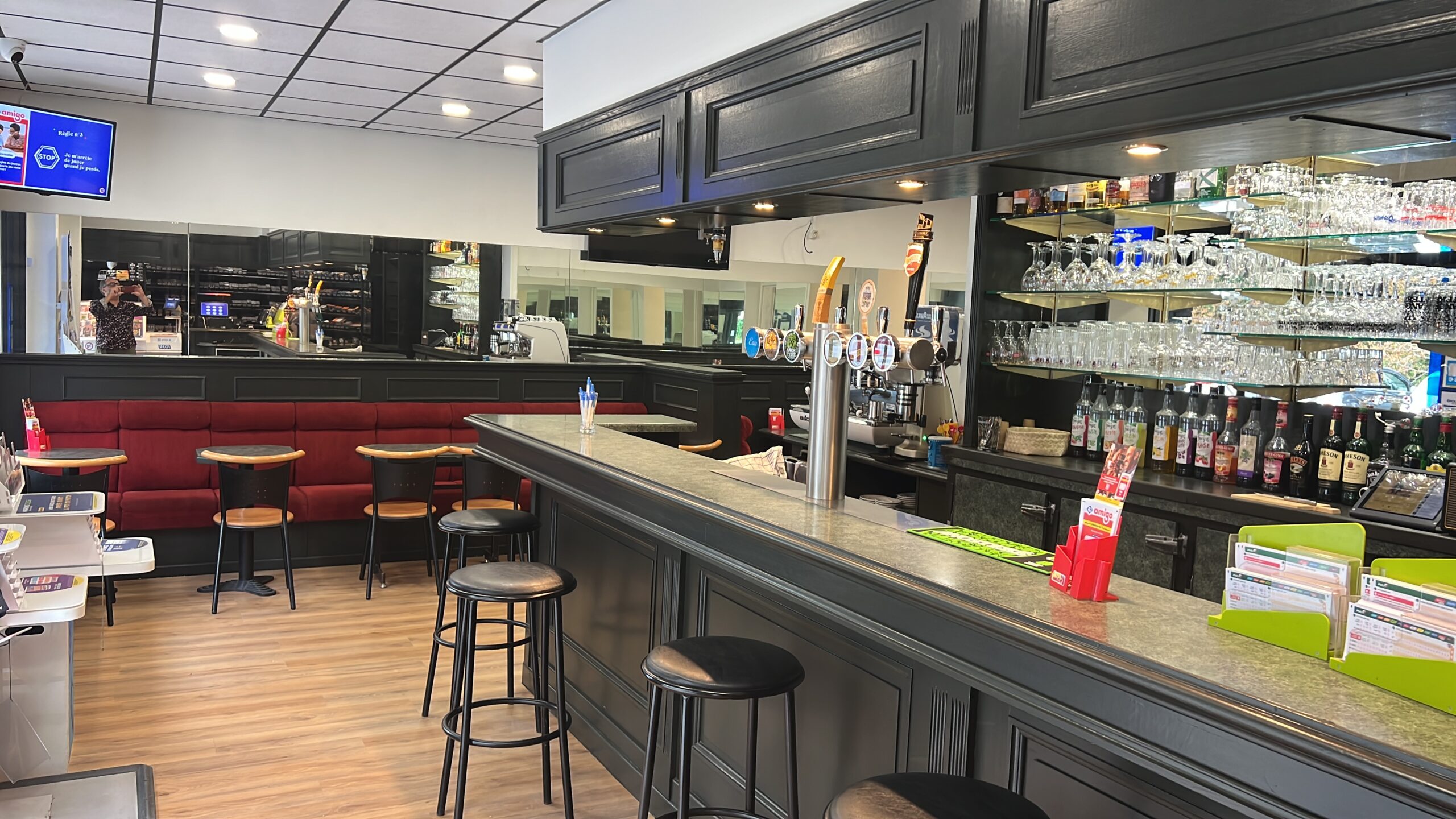 Intérieur panoramique du bar Le Rallye avec comptoir, tireuses et salle